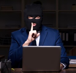 Male employee stealing information in the office night time