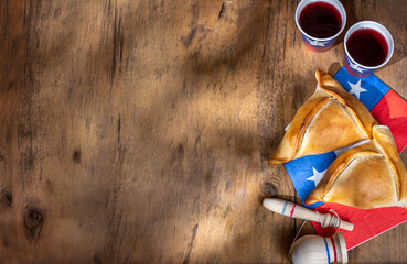 Chilean independence day concept. fiestas patrias. Tipical baked empanadas, wine or chicha, fat and...