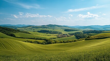 Rolling Green Hills and Lush Countryside Landscape with Village in Distance under Blue Sky with White Clouds.