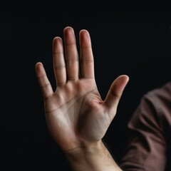Close-Up Photograph of a Hand Raised Against a Dark Background, Perfect for Gestures, Communication, and Palmistry References