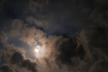 Obraz premium The atmosphere is quiet and serene on a full moon night. Textured Background of bright moonlight surrounded by clouds. Background wallpapers. Nature Photography Concept