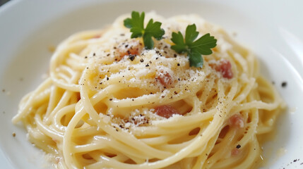 A delicious Carbonara pasta with creamy sauce, Parmesan cheese, bacon bits, and fresh herbs, served on a white plate