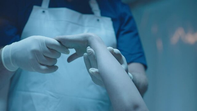 Mortician holding a hand of a cold body