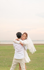 Happy young Asian couple in bride and groom clothing