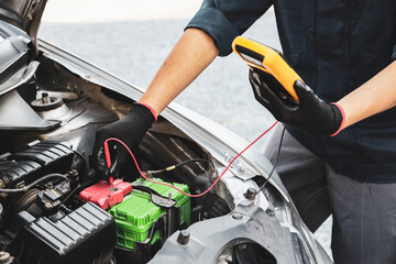 Car mechanic use voltmeter to check voltage battery low energy problem for car care service...
