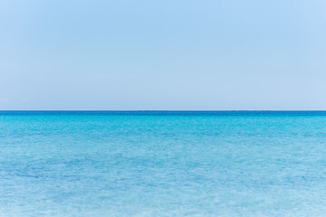 Le Saline beach landscape: turquoise sea meets a distant horizon with faint landforms, under a vast...