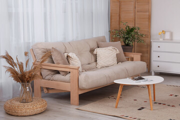 Interior of stylish living room with comfortable sofa, carpet and chest of drawers