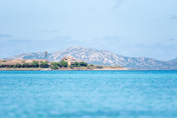 Le Saline beach landscape: turquoise sea meets a distant horizon with faint landforms, under a vast...