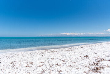 Le Saline beach in Sardinia: blue sky and sea meet white sand. A perfect shot capturing the serene beauty and tranquility of the Mediterranean landscape.