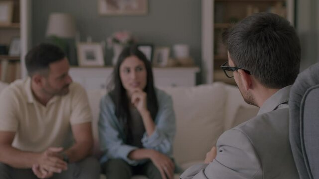 Frustrated couple talking about their problems with marriage counselor at home. 4K video
