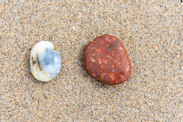 Beach treasure, stone on the beach sand. Close up.
