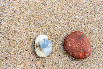 Beach treasure, stones on the beach sand. Close up view. 