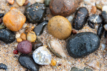 Beach treasure, stones on the beach sand. Close up view. 