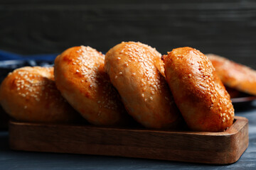 Board with tasty bagels on blue wooden background