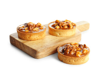 Fototapeta premium Tasty tarts with nuts and caramel on wooden board against white background