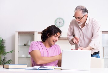 Old father helping his son in exam preparation