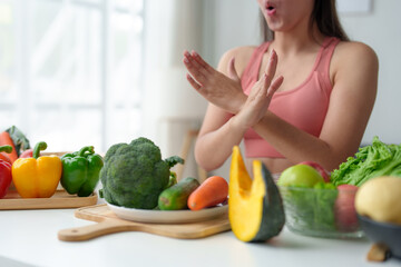 Beautiful Asian woman in exercise clothes. Fitness. Woman wants to control her healthy weight but doesn't want to eat fruits and vegetables. Useful salad dieting concept maintaining body shape.