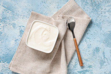 Bowl of tasty yogurt on light blue background