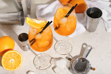 Glasses of Aperol spritz cocktail with oranges on white background