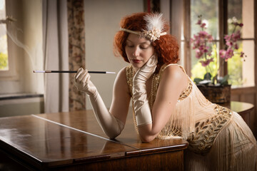 Beautiful model in 20s flapper dress holding a cigarette holder