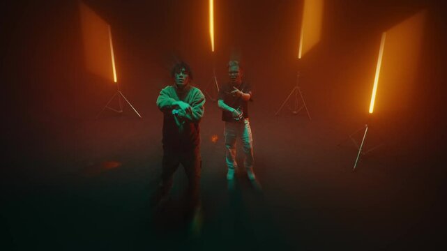 couple of artist singer rapper dancing and sing in front of camera in a studio with red led light