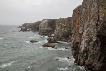 View of rugged cliffs and sea on a cloudy day. Pembrokeshire Coast National Park, Wales