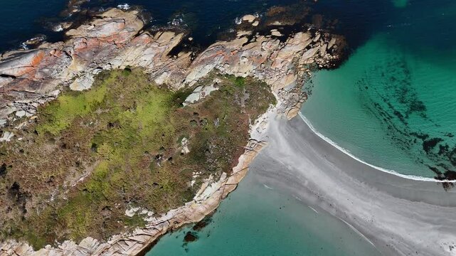 Aerial top down of clear ocean water and sandy path connecting Diamond Island in Tasmania. Sunny summer day in Australia with magnificent nature.