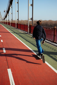 Skateboarder rides smoothly across a city path.