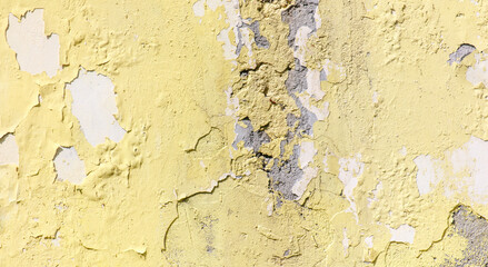 Cracked yellow paint on the wall as an abstract background. Texture
