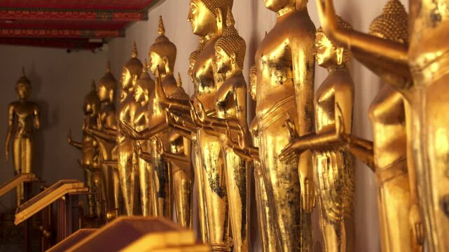 Static handheld shot of golden Buddha statues at Wat Pho temple, Bangkok