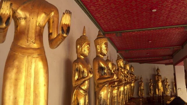 Impressive golden color Buddhist statues at Wat Pho temple in Bangkok, Thailand