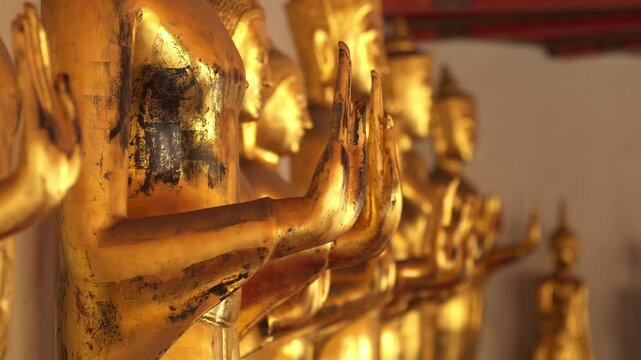 Static shot of golden color statues in line at Wat Pho temple, Thailand