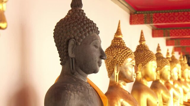Multiple Buddha images in line at Wat Pho temple in Bangkok, Thailand