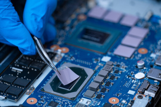 Technician repairing inside of thermal pad for Integrated Circuit. the concept of data, hardware repairing, upgrade technology.	