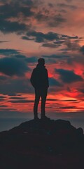 Obraz premium Silhouette of a Man Standing on a Cliff During Sunset