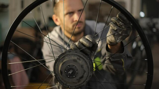 A bicycle master repairs and balances a bicycle wheel. Bicycle service.
