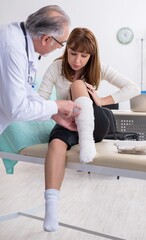 Obraz premium Young injured woman visiting experienced doctor traumatologist