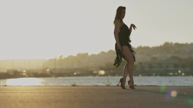Woman performing latin dance routine at sunset