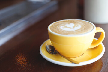 hot coffee cup latte art with spoon Serve ready to drink in cafe on wooden table coffee shop.  Leave copy space empty to write the side text. soft focus.