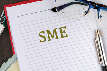 Word SME. Small and medium-sized enterprises - commercial enterprises. The SME symbol in the notebook of a businessman, a top manager, a manager