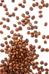 Naklejka premium A scattered arrangement of various coffee beans on a white background, showcasing different shades and textures of roasted coffee.