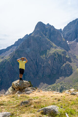 Hiker standing on a rock enjoying the views and the landscape with mountains, in Pirineos, Huesca...