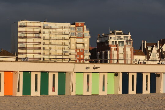 Vue du front de mer au Touquet Paris Plage, dans les Hauts de France, au Nord de la France. Alignement de portes color&eacute;es de cabines de bain.. Ciel gris bleu en arri&egrave;re plan. Photo prise en mai 2024.