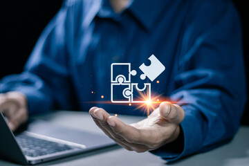 Businessman use laptop with jigsaw icon for solution and leadership strategies concept. Success in...