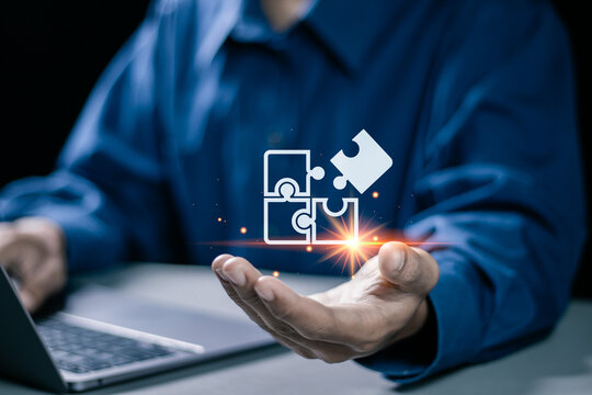 Businessman use laptop with jigsaw icon for solution and leadership strategies concept. Success in problem solving and visionary decision making.