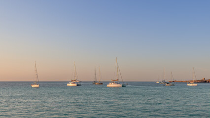 Evening view of sailboats, catamarans anchored in the Mediterranean Sea near Ibiza. The soft sunset...