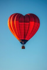 Naklejka premium Red heart shaped hot air balloon flying in the sky