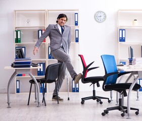Leg injured male employee working in the office