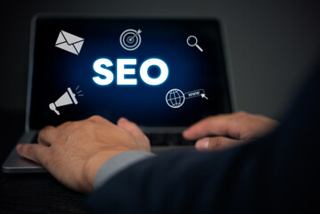 Hands typing on a laptop displaying SEO with digital marketing icons. Enhances understanding of SEO strategy and digital marketing techniques. Ideal for marketing