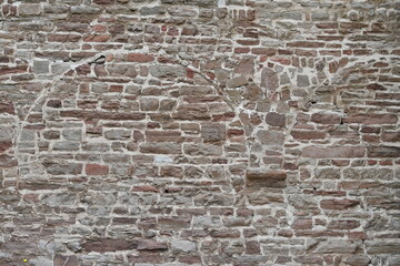 Stone wall of a monastery in which the old remains of a gable or a former door are recognizable